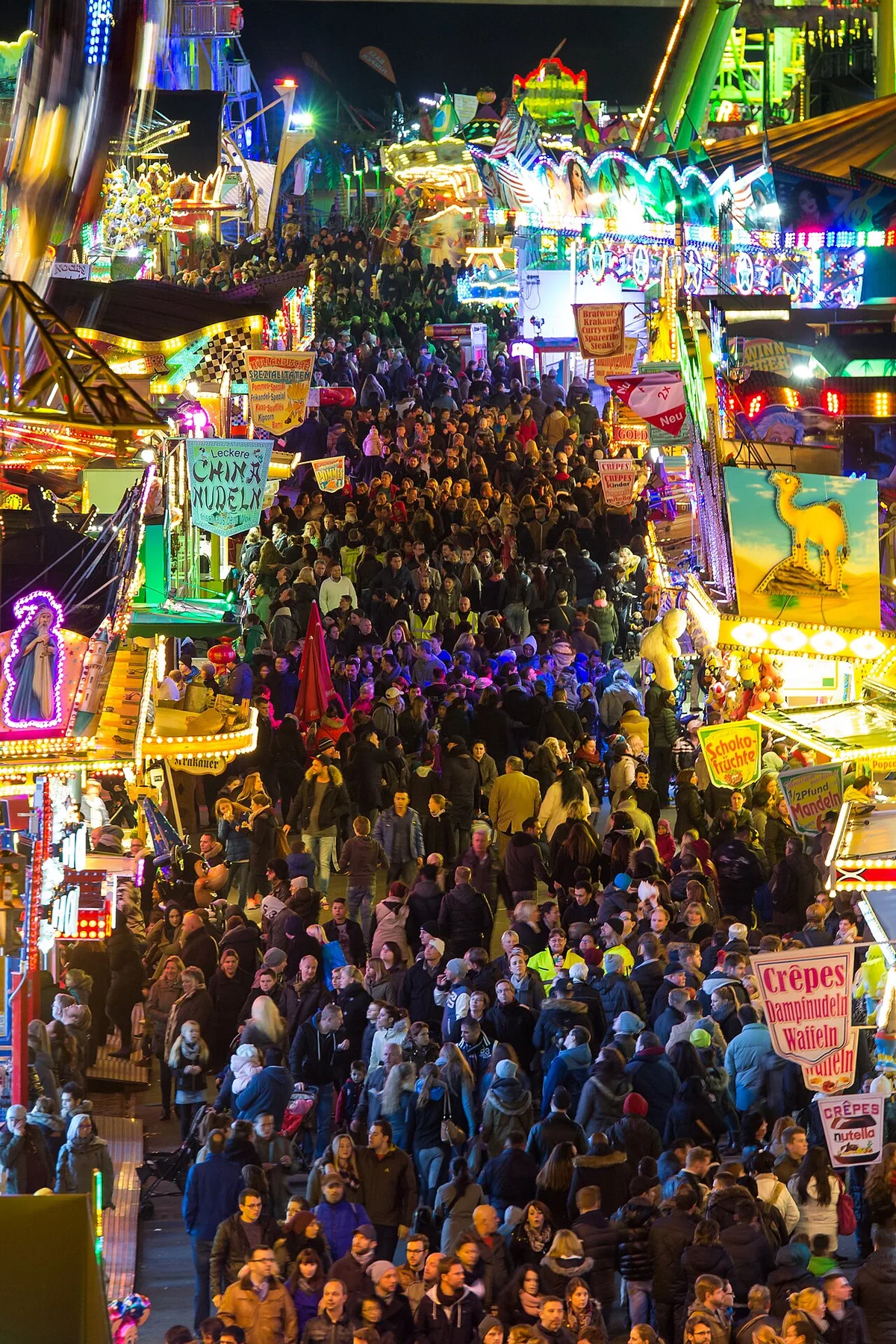 Volle Hauptachse der Deutzer Herbstkirmes am Abend mit bunt beleuchteten Buden und Fahrgeschäften