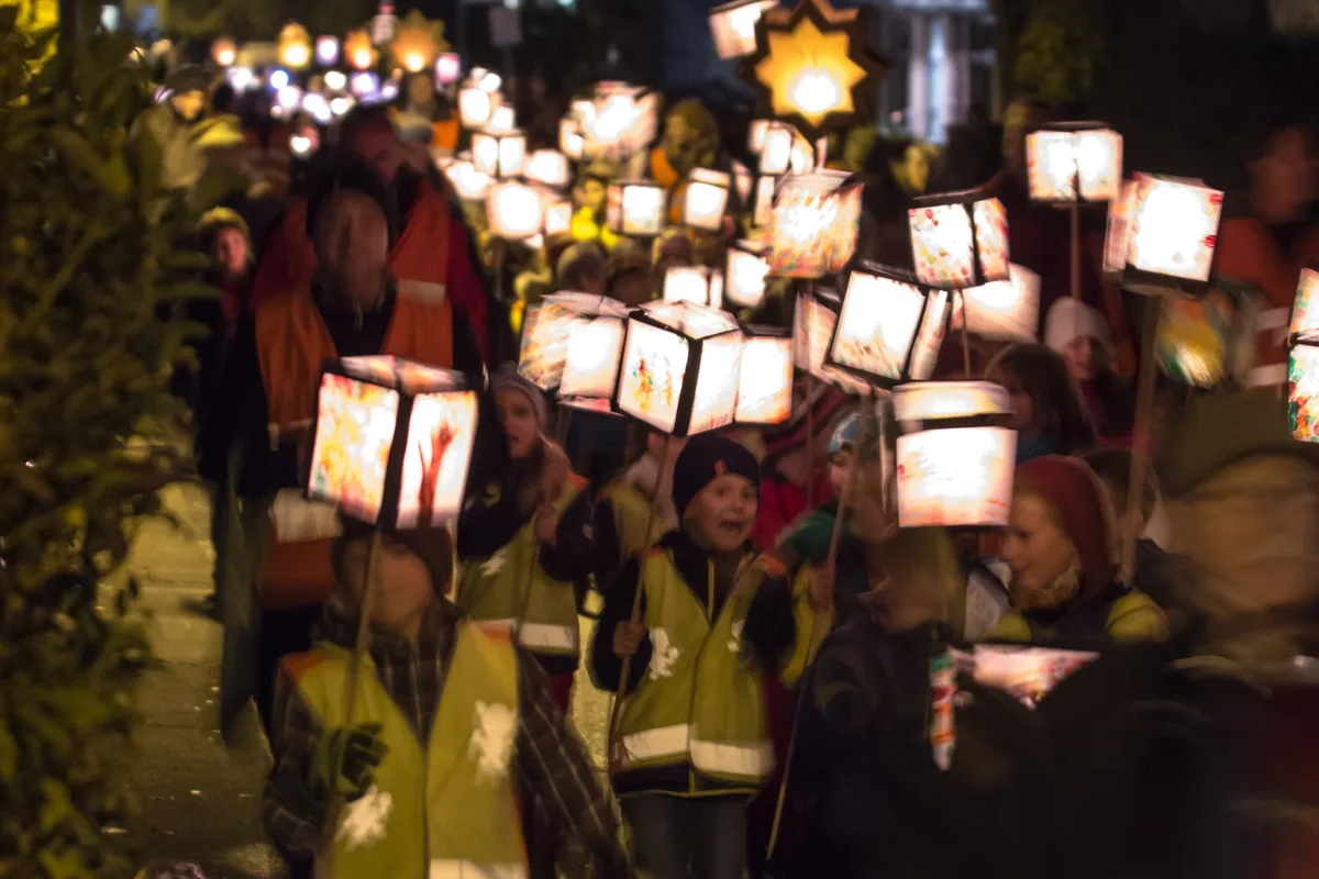 Kinder mit leuchtenden Laternen bei einem abendlichen Martinszug in Köln