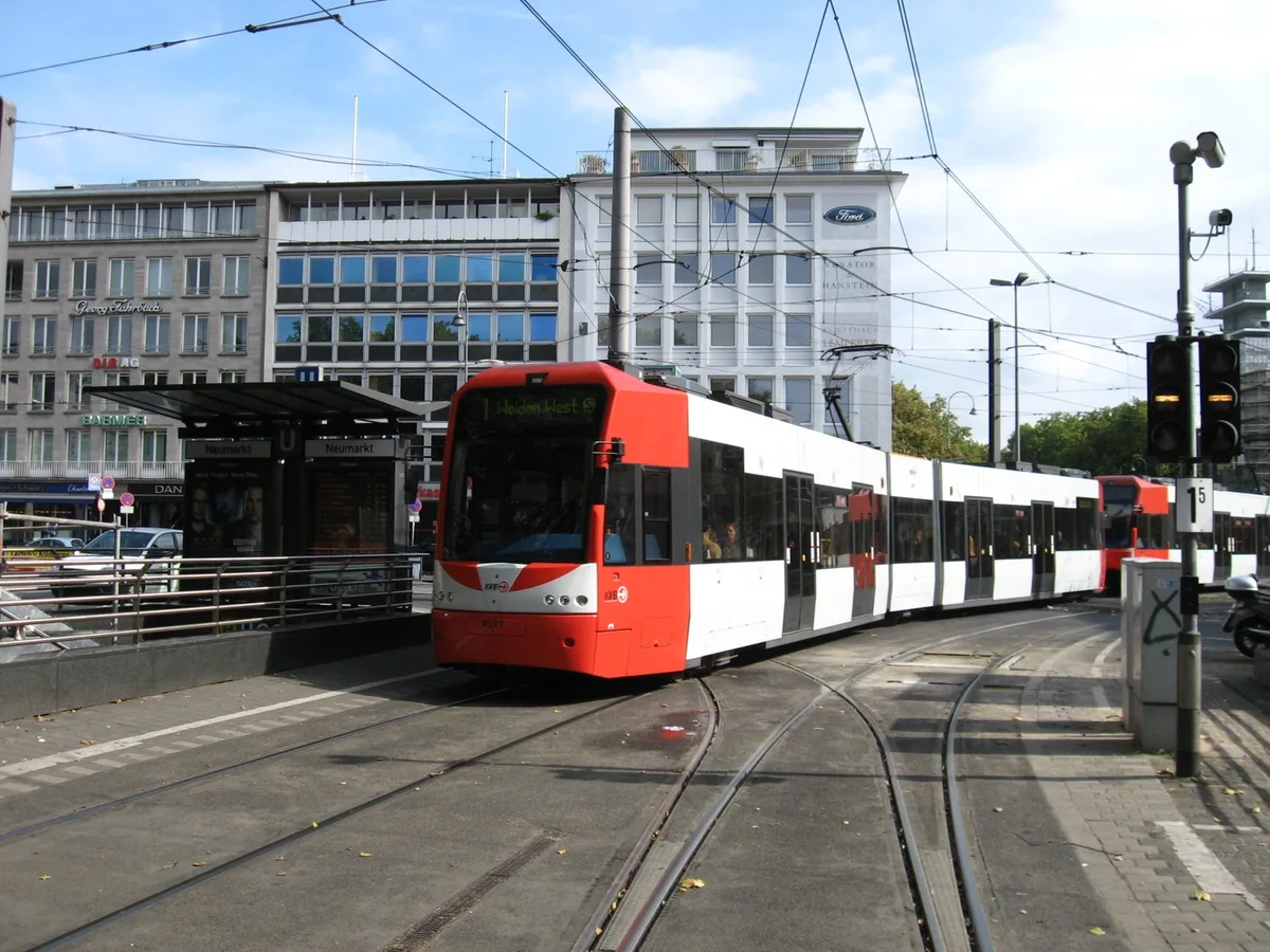 Rot-weiße KVB-Stadtbahn der Linie 1 fährt über die Gleise am Neumarkt in Köln (Archivbild)