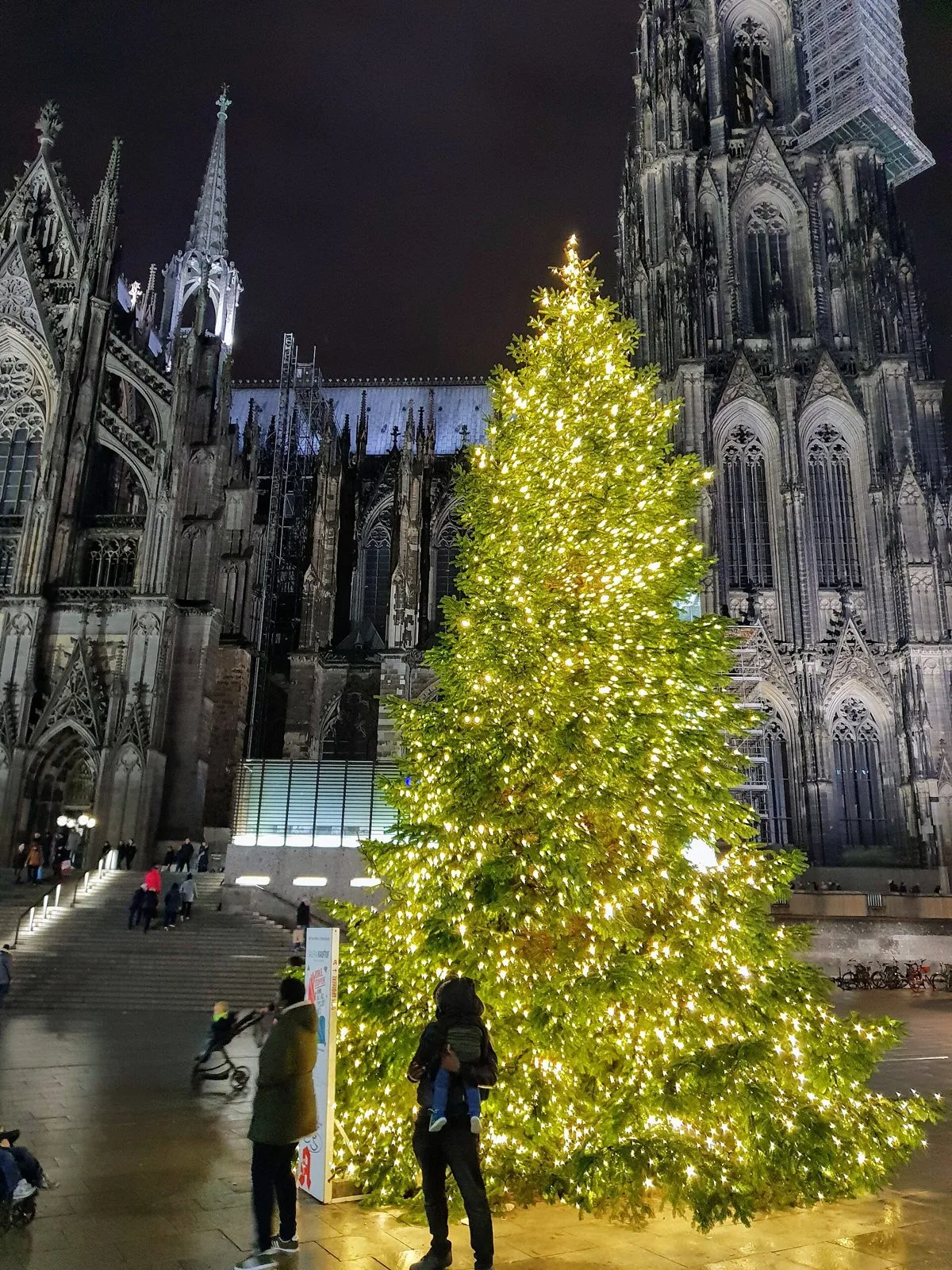 Weihnachtsmarkt am Kölner Dom am Abend mit beleuchteten Buden vor dem Dom